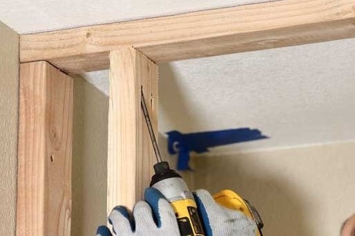 Worker screwing 2x4.