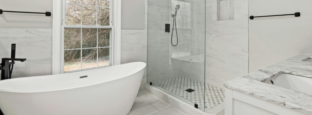 White bathroom with white bub and white tiled shower.
