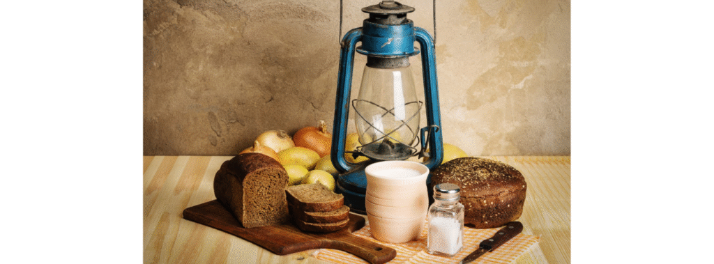 Lantern with a cutting board and food on a table.